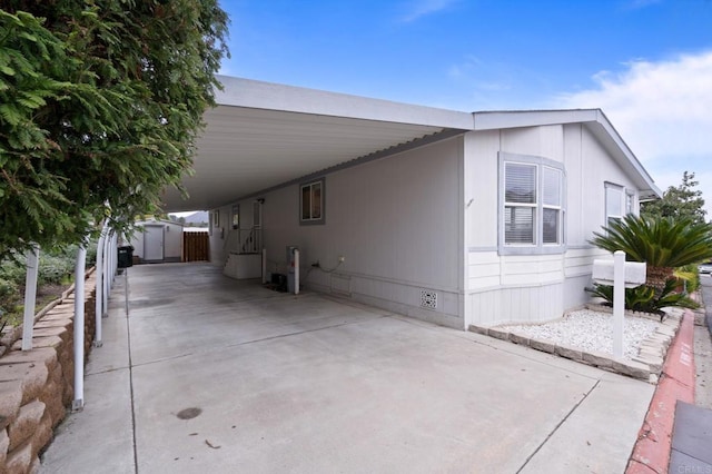 view of property exterior featuring a storage shed and a carport