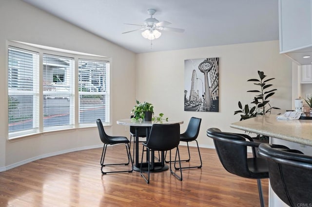 dining space featuring ceiling fan, lofted ceiling, and light hardwood / wood-style flooring