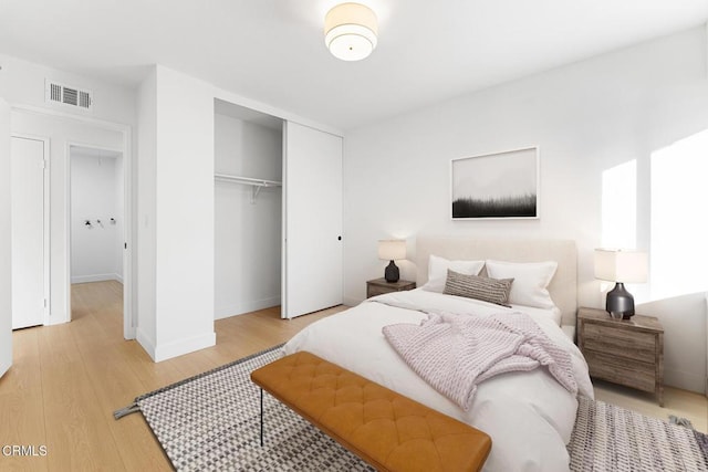 bedroom with light wood-type flooring and a closet