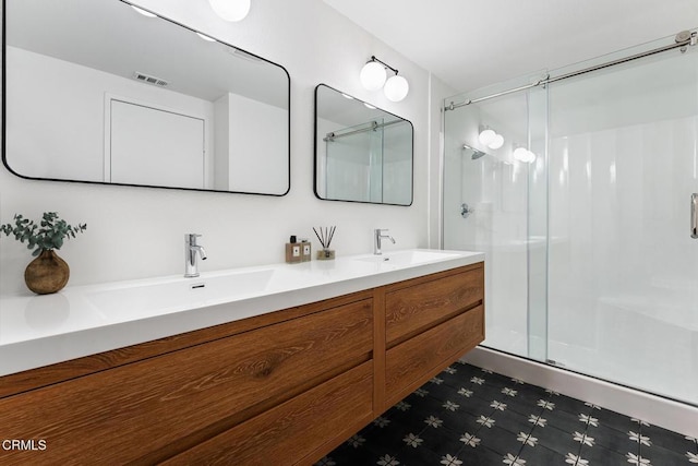 bathroom featuring a shower with door and vanity