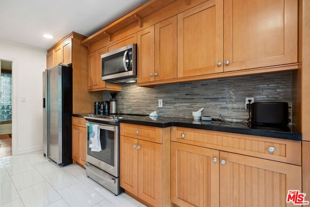 kitchen featuring stainless steel appliances and backsplash