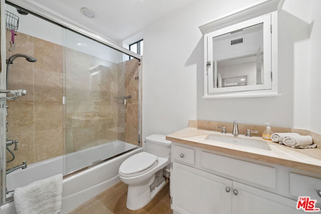 full bathroom featuring enclosed tub / shower combo, vanity, and toilet