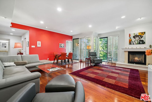 living room with hardwood / wood-style flooring and crown molding