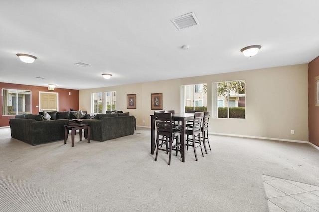 carpeted dining area with baseboards and visible vents