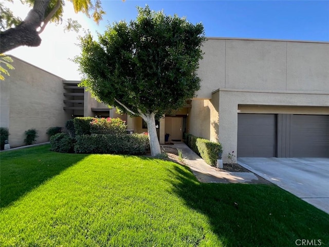 1137 Tiffany Cir S, Palm Springs, CA 92262 - view of front facade with a front lawn, a garage, driveway, and stucco siding