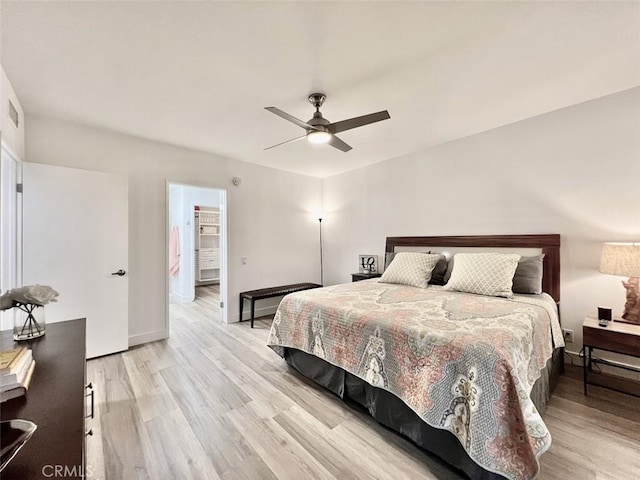 bedroom featuring ceiling fan, light wood finished floors, visible vents, and baseboards