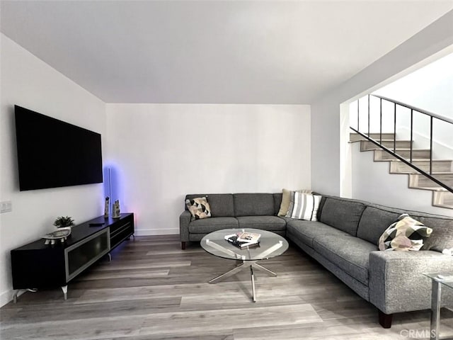 living area with stairway and wood finished floors