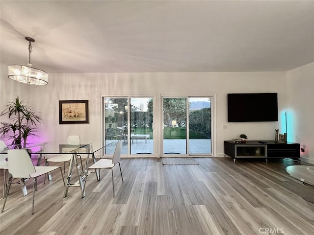 interior space with a chandelier, baseboards, and light wood-style floors