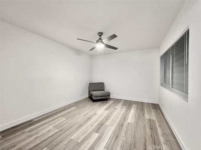 unfurnished room featuring light wood-type flooring, ceiling fan, and baseboards