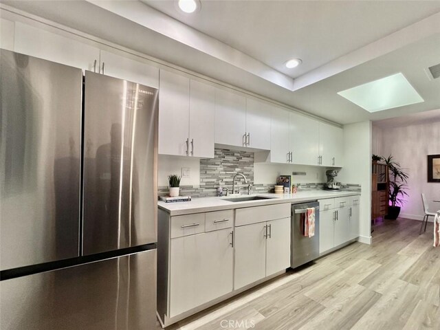 1137 Tiffany Cir S, Palm Springs, CA 92262 - kitchen with stainless steel appliances, a sink, light countertops, a skylight, and recessed lighting
