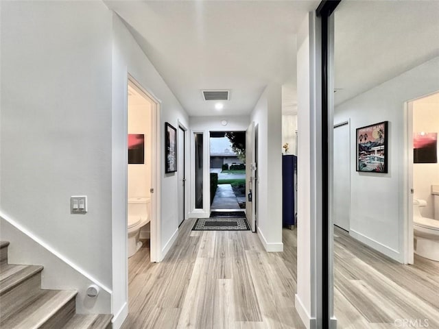 entryway featuring light wood-type flooring, visible vents, stairway, and baseboards