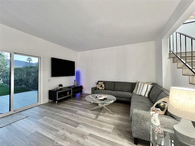 living room with stairway, wood finished floors, and baseboards