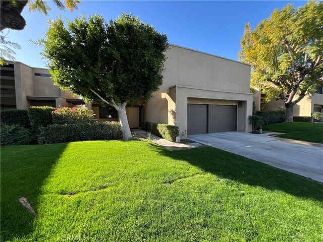 1137 Tiffany Cir S, Palm Springs, CA 92262 - view of front of home featuring concrete driveway, a front lawn, stucco siding, and a garage