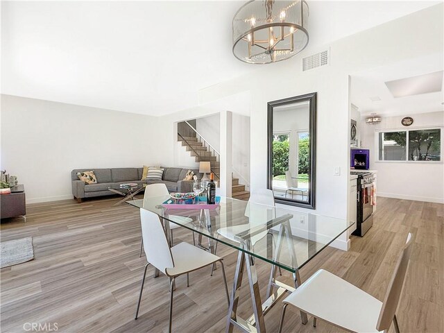 1137 Tiffany Cir S, Palm Springs, CA 92262 - dining space with stairs, light wood-style floors, and a chandelier
