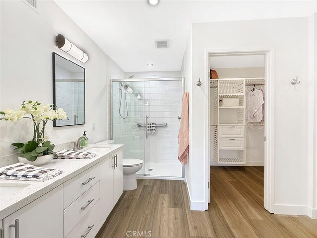 1137 Tiffany Cir S, Palm Springs, CA 92262 - bathroom with double vanity, a walk in closet, a stall shower, and wood finished floors