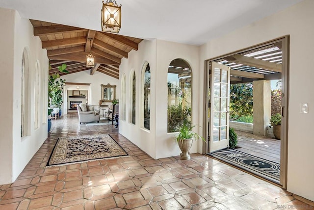 entryway featuring wooden ceiling and vaulted ceiling with beams