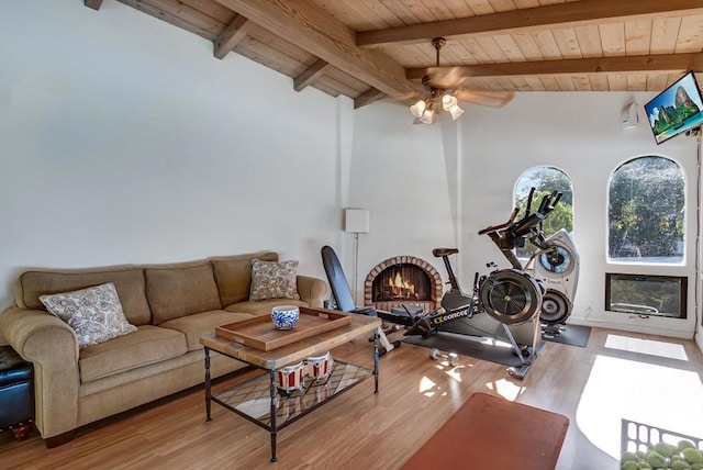 workout area with vaulted ceiling, light hardwood / wood-style flooring, wooden ceiling, ceiling fan, and a fireplace