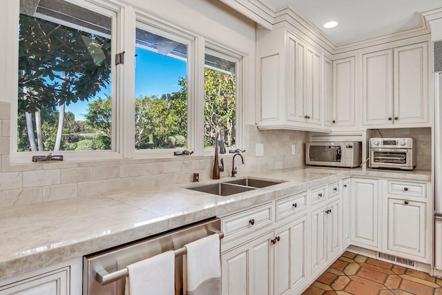 kitchen with tasteful backsplash, white cabinetry, and stainless steel dishwasher