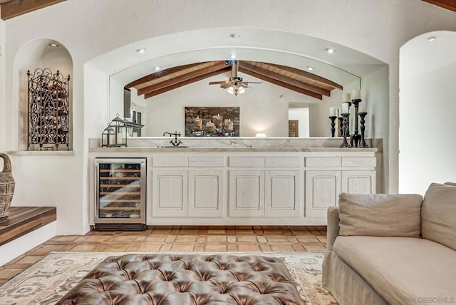 bar featuring white cabinetry, vaulted ceiling with beams, beverage cooler, and ceiling fan