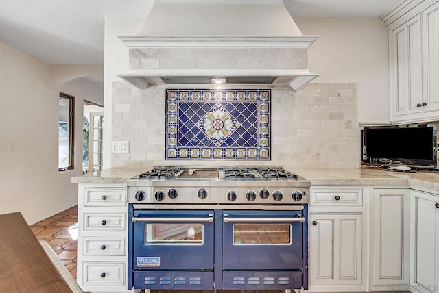 kitchen featuring light tile patterned floors, white cabinetry, double oven range, backsplash, and custom exhaust hood