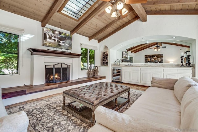 living room with vaulted ceiling with beams, wooden ceiling, beverage cooler, and ceiling fan