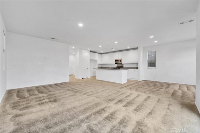 unfurnished living room with light colored carpet