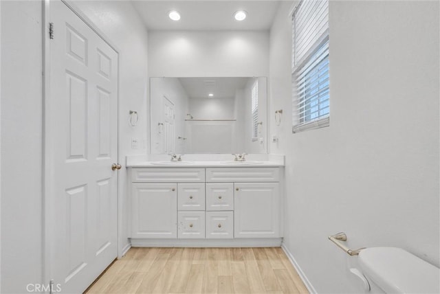 bathroom featuring hardwood / wood-style flooring, vanity, toilet, and walk in shower