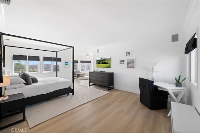 bedroom with multiple windows, crown molding, and light hardwood / wood-style flooring