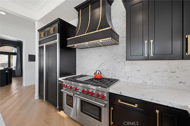 kitchen with premium range hood, premium appliances, ornamental molding, light hardwood / wood-style floors, and backsplash