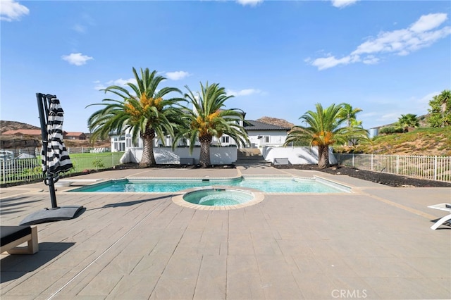 view of pool featuring a patio and an in ground hot tub