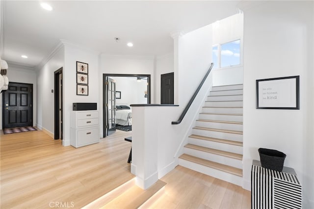 staircase featuring ornamental molding and hardwood / wood-style floors