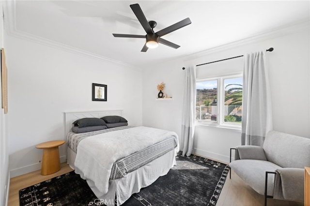 bedroom featuring hardwood / wood-style flooring, ceiling fan, and ornamental molding