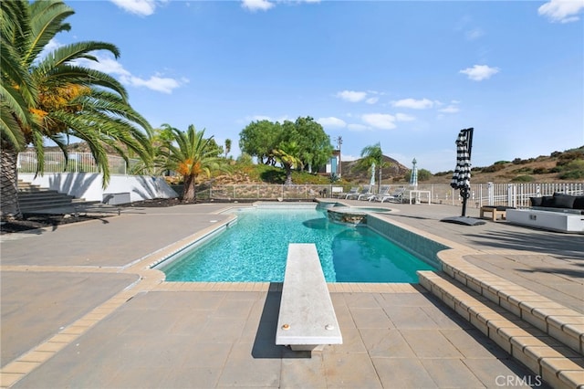 view of pool featuring an in ground hot tub, a diving board, and a patio