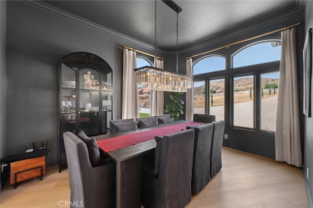 dining space featuring crown molding and light hardwood / wood-style flooring