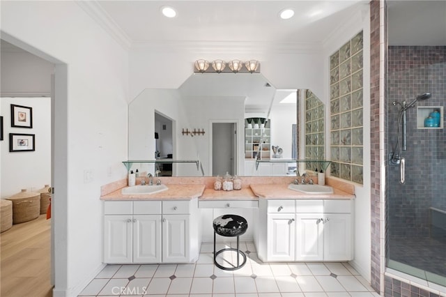 bathroom featuring ornamental molding, a shower with shower door, and vanity