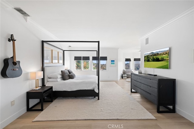 bedroom with crown molding and light wood-type flooring