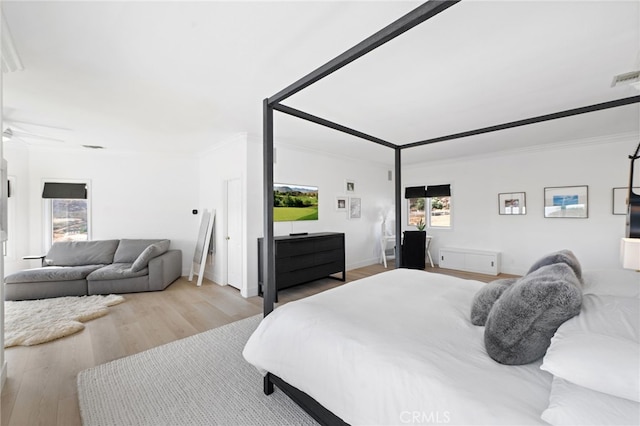 bedroom featuring crown molding and light wood-type flooring