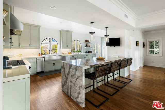 kitchen featuring crown molding, dark wood-type flooring, hanging light fixtures, a center island, and decorative backsplash