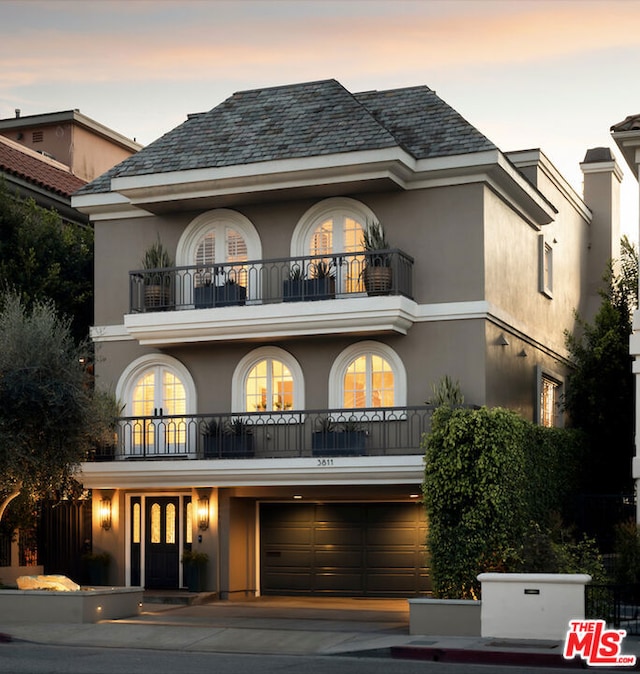 view of front of home with a garage and a balcony