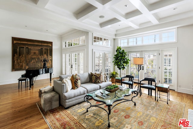 living room with coffered ceiling, wood-type flooring, beamed ceiling, and a high ceiling