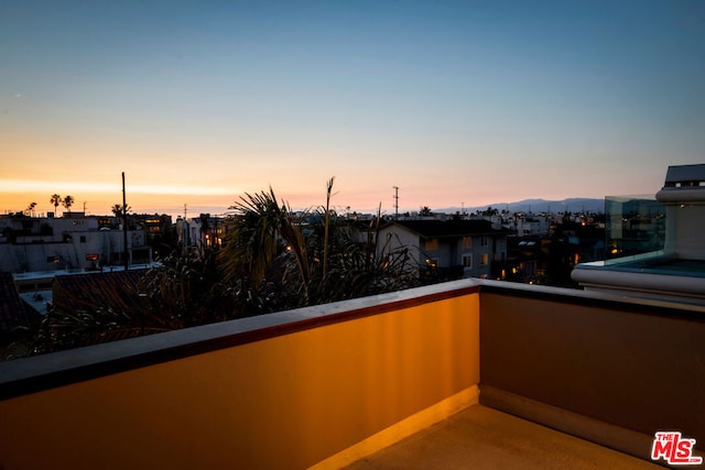 patio terrace at dusk featuring a balcony