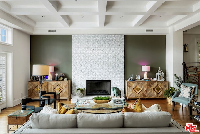 living room with hardwood / wood-style flooring, coffered ceiling, and a tiled fireplace