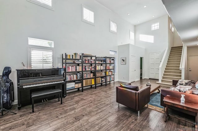 living room featuring a towering ceiling and hardwood / wood-style floors