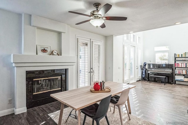 dining space featuring wood-type flooring, ceiling fan, and french doors