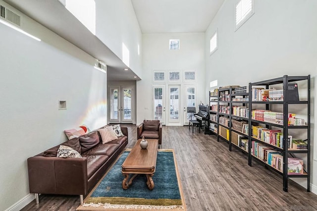 living room featuring dark wood-type flooring, french doors, and plenty of natural light