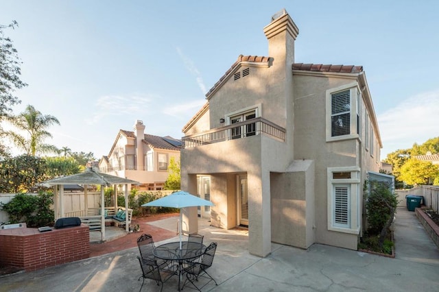 back of house with a gazebo, a balcony, and a patio