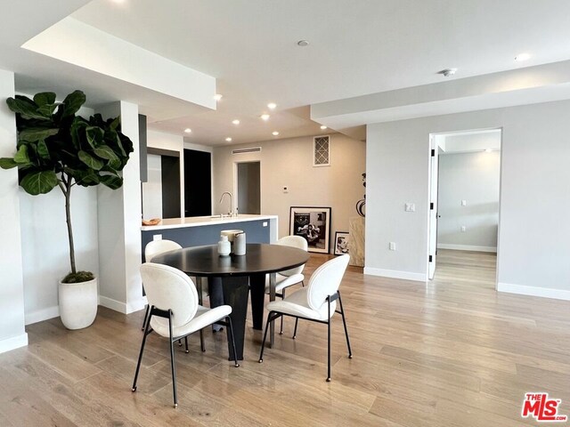 dining room with sink and light wood-type flooring