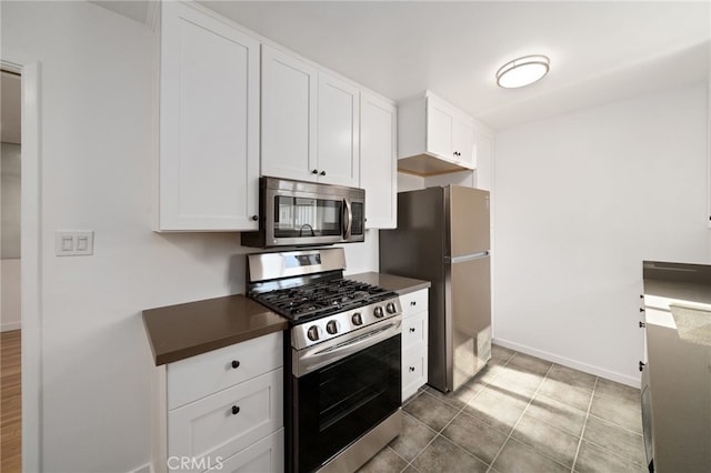 734 Linden Ave Unit 7, Long Beach, CA 90813 - kitchen with appliances with stainless steel finishes, dark countertops, white cabinets, and tile patterned floors