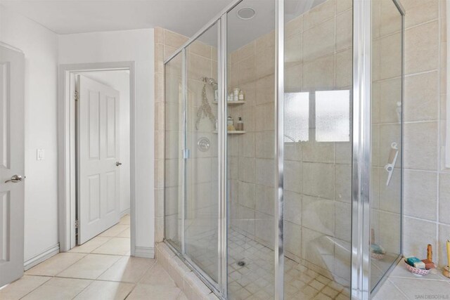 bathroom with tile patterned flooring and a shower with shower door