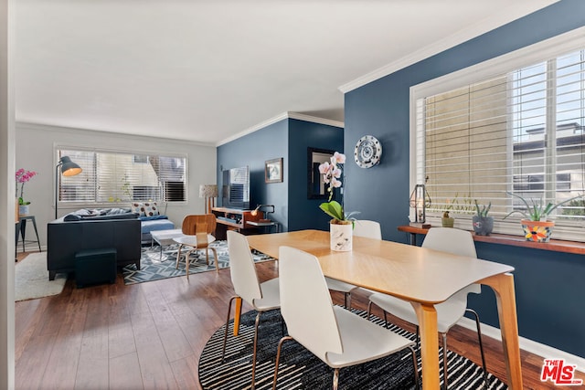 dining space with ornamental molding and dark hardwood / wood-style flooring